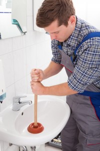 stock-photo-portrait-of-male-plumber-pressing-plunger-in-sink-149246570